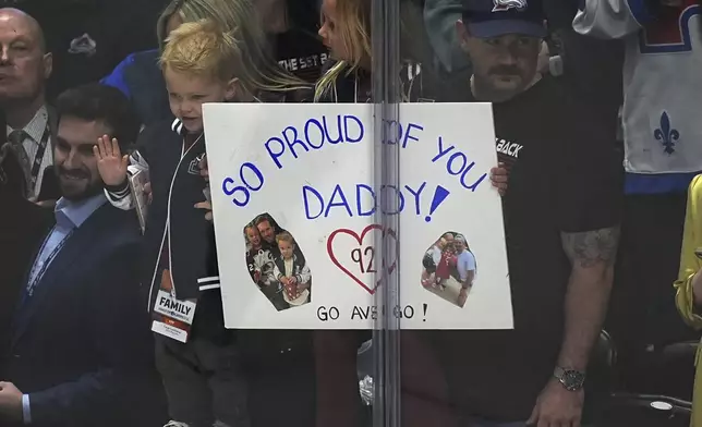 Family of Colorado Avalanche left wing Gabriel Landeskog holds placard as he warms up before the first period of Game 3 of an NHL first-round hockey playoff series against the Dallas Stars Wednesday, April 23, 2025, in Denver. (AP Photo/David Zalubowski)