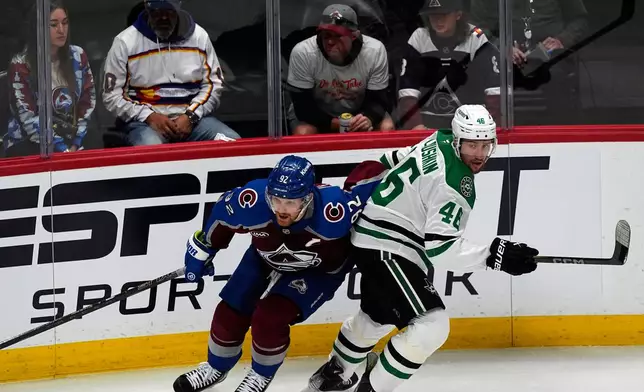 Colorado Avalanche left wing Gabriel Landeskog, left, pursues the puck with Dallas Stars defenseman Ilya Lyubushkin in the first period of Game 3 of an NHL hockey first-round playoff series Wednesday, April 23, 2025, in Denver. (AP Photo/David Zalubowski)