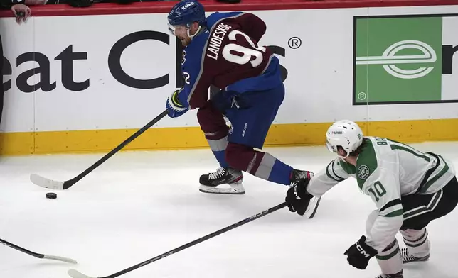 Colorado Avalanche left wing Gabriel Landeskog, top, collects the puck as Dallas Stars center Oskar Bäck pursues in the first period of Game 3 of an NHL hockey first-round playoff series Wednesday, April 23, 2025, in Denver. (AP Photo/David Zalubowski)