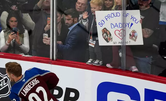 Family members hold up a placard in support of Colorado Avalanche left wing Gabriel Landeskog as he warms up before the first period of Game 3 of an NHL first-round hockey playoff series against the Dallas Stars Wednesday, April 23, 2025, in Denver. (AP Photo/David Zalubowski)