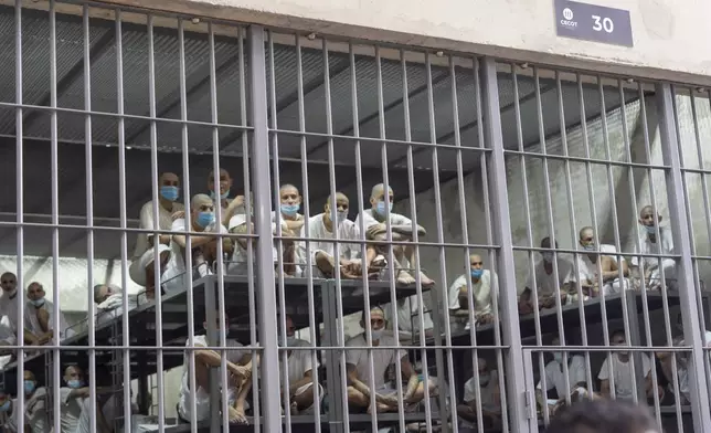 Prisoners look out of their cell as Homeland Security Secretary Kristi Noem tours the Terrorist Confinement Center in Tecoluca, El Salvador, Wednesday, March 26, 2025. (AP Photo/Alex Brandon)