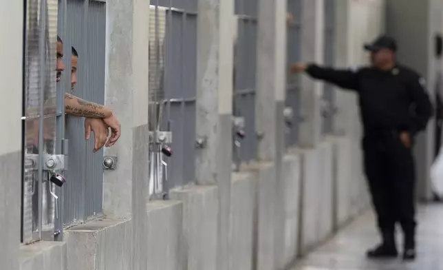 Prisoners look out their cell as Homeland Security Secretary Kristi Noem tours the Terrorist Confinement Center in Tecoluca, El Salvador, Wednesday, March 26, 2025. (AP Photo/Alex Brandon)