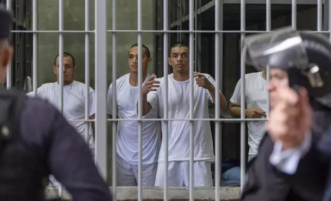 Prisoners look out their cell as Homeland Security Secretary Kristi Noem tours the Terrorist Confinement Center in Tecoluca, El Salvador, Wednesday, March 26, 2025. (AP Photo/Alex Brandon)