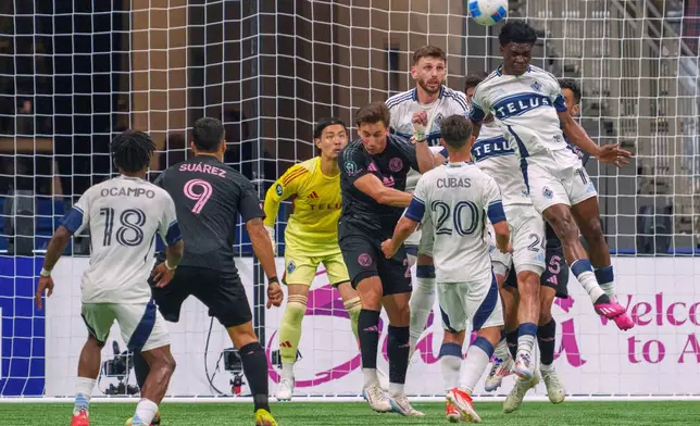 Vancouver Whitecaps' Emmanuel Sabbi, right, goes for a header against Inter Miami during the second half of a CONCACAF Champions Cup semifinal soccer match, in Vancouver, British Columbia, Thursday, April 24, 2025. (Christopher Morris/The Canadian Press via AP)