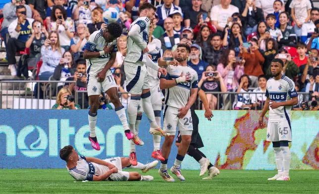 Vancouver Whitecaps' Emmanuel Sabbi, left, tries to block a free kick by Inter Miami's Lionel Messi, not shown, with teammatesduring the second half of a CONCACAF Champions Cup semifinal soccer match, in Vancouver, British Columbia, Thursday, April 24, 2025. (Christopher Morris/The Canadian Press via AP)