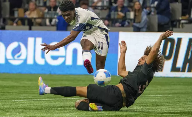 Vancouver Whitecaps' Emmanuel Sabbi, top, kicks the ball past Inter Miami's Maximiliano Falcon during the second half of a CONCACAF Champions Cup semifinal soccer match, in Vancouver, British Columbia, Thursday, April 24, 2025. (Christopher Morris/The Canadian Press via AP)
