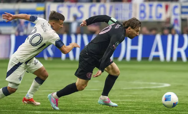 Inter Miami's Lionel Messi, right, is pursued by Vancouver Whitecaps' Andres Cubas, left, during the first half of a CONCACAF Champions Cup semifinal soccer match in Vancouver, British Columbia, Thursday, April 24, 2025. (Christopher Morris/The Canadian Press via AP)