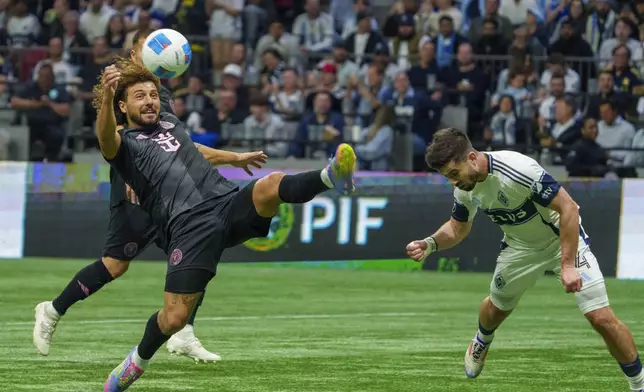 Inter Miami's Maximiliano Falcon, left, kicks the ball in front of Vancouver Whitecaps' Brian White during the second half of a CONCACAF Champions Cup semifinal soccer match, in Vancouver, British Columbia, Thursday, April 24, 2025. (Christopher Morris/The Canadian Press via AP)