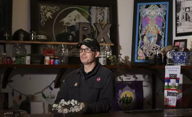 Marine Corps combat veteran Matt Metzger poses for a portrait with a plate of mushrooms that he grows himself for microdosing psilocybin, Wednesday, March 26, 2025, in Olympia, Wash. (AP Photo/Lindsey Wasson)