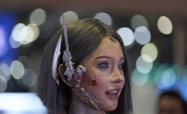 A vlogger who dressed up to look like a humanoid robot reacts at the Shanghai auto show on Thursday, April 24, 2025. (AP Photo/Ng Han Guan)
