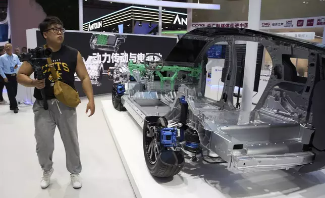 A man walks past a cut out showing the parts from Chinese auto parts manufacturer CCAG during the Shanghai auto show on Thursday, April 24, 2025. (AP Photo/Ng Han Guan)