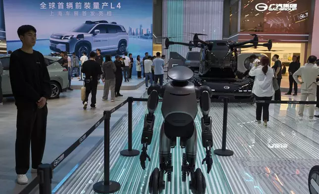 A wheeled robot and a flying vehicle is displayed at the AION and GAC Group booths at the Shanghai auto show on Thursday, April 24, 2025. (AP Photo/Ng Han Guan)