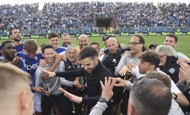 Como's coach Cesc Fabregas, center, celebrates his side's 1-0 win at the end of the Serie A soccer match between Como and Genoa at the Giuseppe Sinigaglia stadium in Como, Italy, Sunday April 27 2025. (Antonio Saia/LaPresse via AP)
