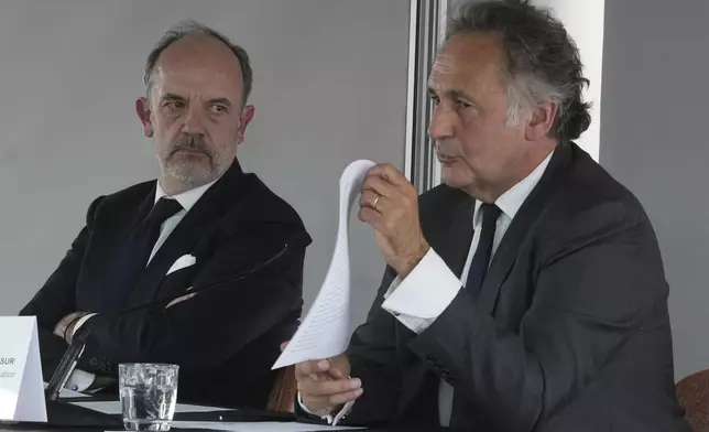 Kylian Mbappe's lawyers Pierre Olivier Sur, right, shows a document as Thomas Clay looks on, during a press conference as Kylian Mbappe's legal team is going on the attack to try and solve the legal dispute between the World Cup winner and his former club PSG, Thursday, April 10, 2025 in Paris. (AP Photo/Michel Euler)