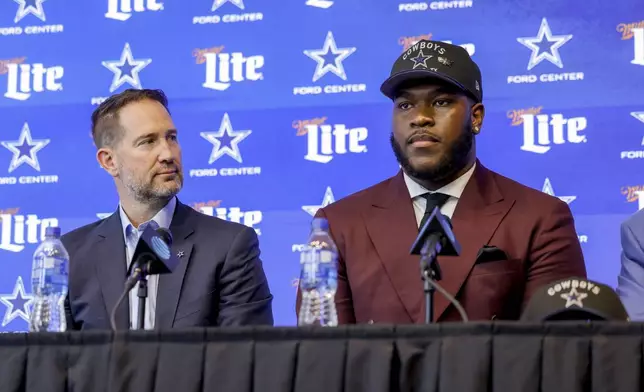 Dallas Cowboys head coach Brian Schottenheimer, left, and first round draft pick Tyler Booker, right, look on during an NFL football press conference in Frisco, Texas, Friday, April 25, 2025. (AP Photo/Gareth Patterson)