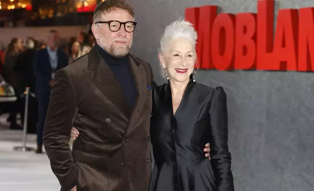 Director Guy Ritchie, left, and Helen Mirren pose for photographers upon arrival at the premiere of 'MobLand' on Thursday, March 27, 2025, in London. (Photo by Millie Turner/Invision/AP)