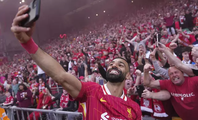 Liverpool's Mohamed Salah celebrates by taking a selfie after winning the English Premier League soccer match between Liverpool and Tottenham Hotspur and clinching the Premier League title at Anfield in Liverpool, England, Sunday, April 27, 2025. (AP Photo/Jon Super)