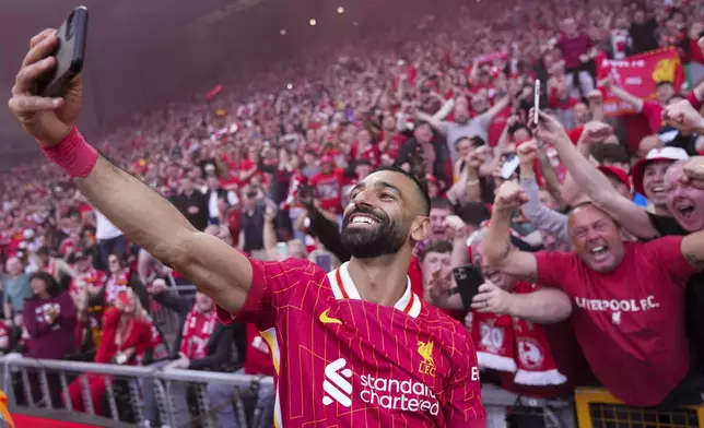 Liverpool's Mohamed Salah celebrates by taking a selfie after winning the English Premier League soccer match between Liverpool and Tottenham Hotspur and clinching the Premier League title at Anfield in Liverpool, England, Sunday, April 27, 2025. (AP Photo/Jon Super)