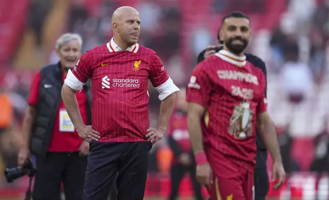 Liverpool's manager Arne Slot, left, and Liverpool's Mohamed Salah celebrate after winning the English Premier League soccer match between Liverpool and Tottenham Hotspur and clinching the Premier League title at Anfield in Liverpool, England, Sunday, April 27, 2025. (AP Photo/Jon Super)