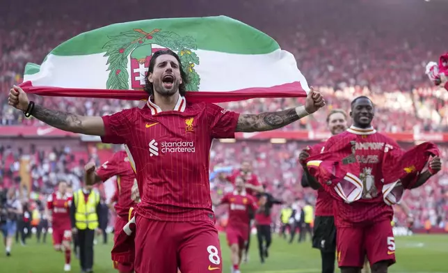 Liverpool's Dominik Szoboszlai celebrates with teammates after winning the English Premier League soccer match between Liverpool and Tottenham Hotspur and clinching the Premier League title at Anfield in Liverpool, England, Sunday, April 27, 2025. (AP Photo/Jon Super)