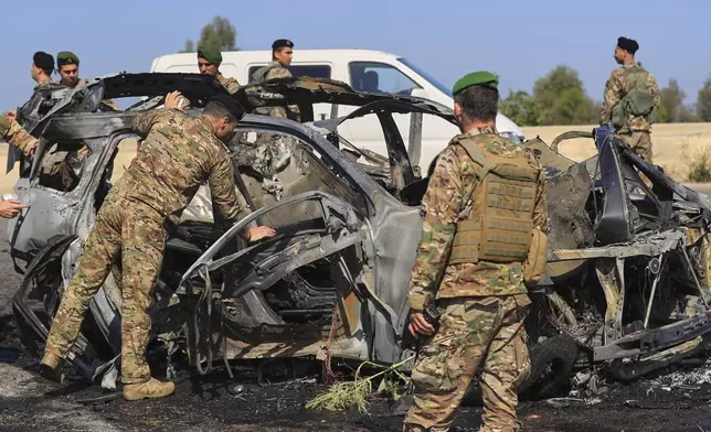 Lebanese army soldiers inspect a charred car that was hit by an Israeli strike, in the southern coastal town of Ghazieh, Lebanon, Friday, April 18, 2025. (AP Photo/Mohammed Zaatari)