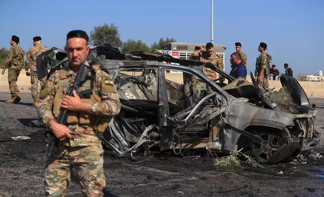 Lebanese army members gather near a charred car that was hit by an Israeli strike, in the southern coastal town of Ghazieh, Lebanon, Friday, April 18, 2025. (AP Photo/Mohammed Zaatari)