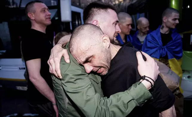 A Ukrainian soldier hugs his comrade after returning from captivity in a POW exchange in Ukraine, on Saturday, April. 19, 2025. (AP Photo/Evgeniy Maloletka)