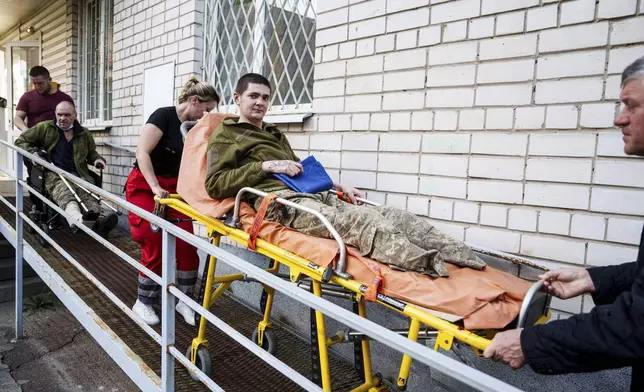 A medical worker uses a stretcher to move an injured Ukrainian soldier after returning from captivity in a POW exchange in Ukraine, on Saturday, April. 19, 2025. (AP Photo/Evgeniy Maloletka)