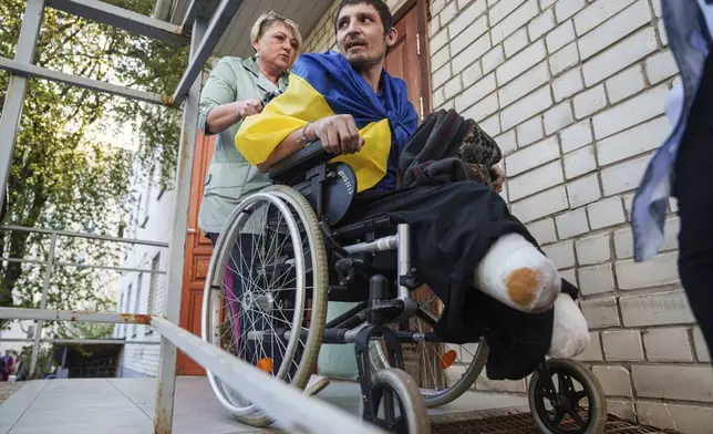 A medical worker uses a wheelchair to move an injured Ukrainian soldier from an ambulance after returning from captivity in a POW exchange in Ukraine, on Saturday, April. 19, 2025. (AP Photo/Evgeniy Maloletka)