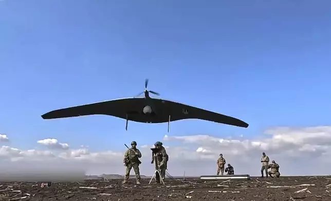 In this photo taken from video distributed by Russian Defense Ministry Press Service on Friday, April 18, 2025, Russian soldiers launch a Supercam intelligence unmanned aerial vehicle towards Ukrainian positions in Ukraine. (Russian Defense Ministry Press Service via AP)
