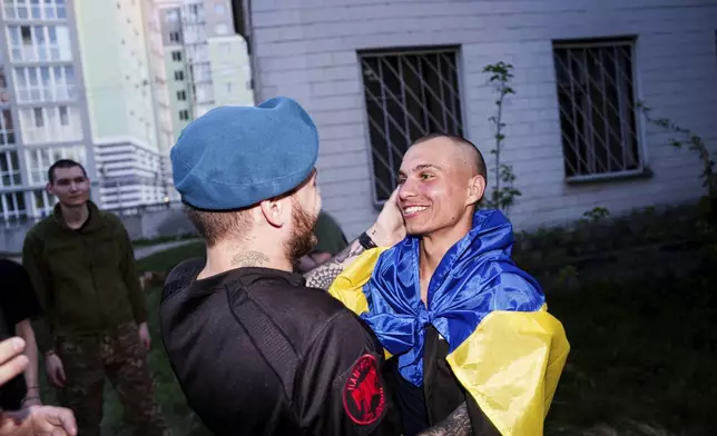 A Ukrainian soldier hugs his comrade after returning from captivity in a POW exchange in Ukraine, on Saturday, April. 19, 2025. (AP Photo/Evgeniy Maloletka)