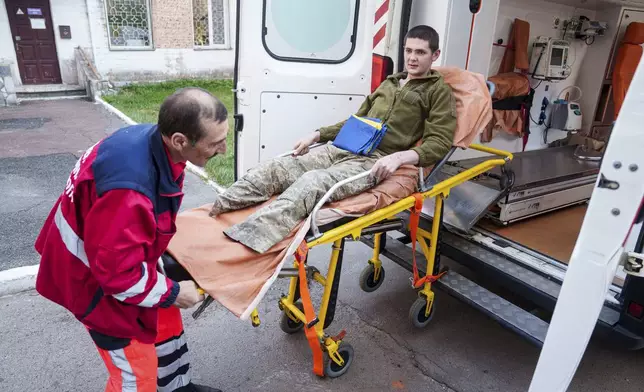 A medical worker moves an injured Ukrainian soldier from an ambulance after returning from captivity in a POW exchange in Ukraine, on Saturday, April. 19, 2025. (AP Photo/Evgeniy Maloletka)