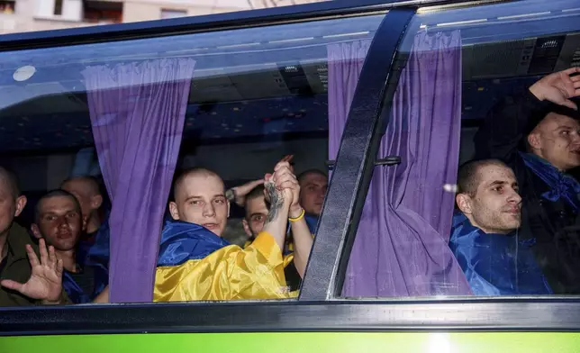 Ukrainian servicemen ride in a bus after returning from captivity in a POW exchange in Ukraine, on Saturday, April. 19, 2025. (AP Photo/Evgeniy Maloletka)