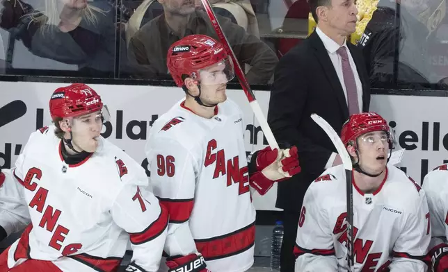 Carolina Hurricanes head coach Rod Brind'Amour watches action behind players Mark Jankowski (77), Jack Roslovic (96) and his son Skyler Brind'Amour during first period NHL hockey action against the Montreal Canadiens in Montreal on Wednesday, April 16, 2025. (Christinne Muschi/The Canadian Press via AP)