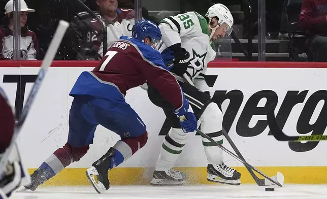 Colorado Avalanche defenseman Devon Toews, left, fights for control of the puck with Dallas Stars center Matt Duchene, right, in the second period of Game 4 of an NHL hockey first-round playoff series Saturday, April 26, 2025, in Denver. (AP Photo/David Zalubowski)