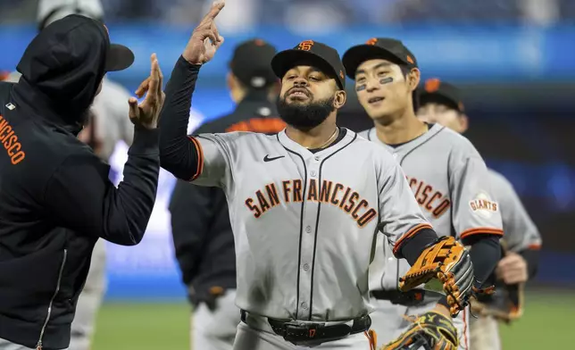 San Francisco Giants left fielder Heliot Ramos, center, celebrates the win with teammates after the baseball game against the Philadelphia Phillies, Wednesday, April 16, 2025, in Philadelphia. (AP Photo/Chris Szagola)