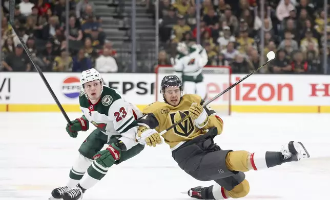 Minnesota Wild center Marco Rossi (23) and Vegas Golden Knights center Brett Howden (21) collide during the third period in Game 1 of an NHL hockey Stanley Cup first-round playoff series Sunday, April 20, 2025, in Las Vegas. (AP Photo/Ian Maule)