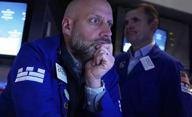 Specialist Meric Greenbaum, left, works at his post on the floor of the New York Stock Exchange, Thursday, April 17, 2025. (AP Photo/Richard Drew)