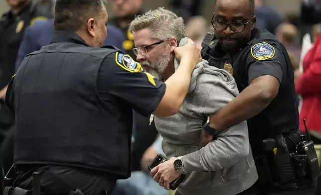 A protester is removed as Rep. Marjorie Taylor Greene, R-Ga., speaks during a town-hall style meeting, Tuesday, April 15, 2025, in Acworth, Ga. (AP Photo/Mike Stewart)