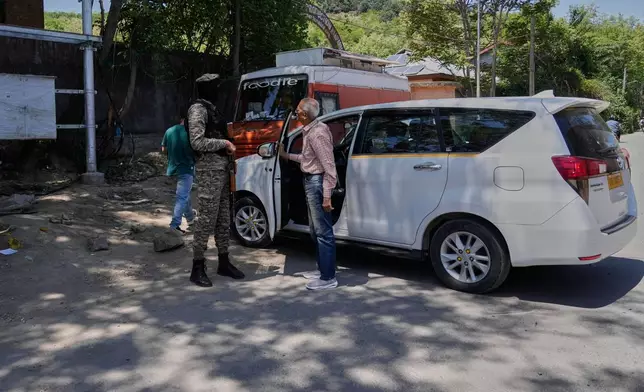 An Indian paramilitary soldier talks with tourists outside a garden in Srinagar after it was closed by authorities as a precautionary safety measure following last week's deadly attack on tourists near the resort town of Pahalgam, Indian controlled Kashmir, Tuesday, April 29, 2025. (AP Photo/Mukhtar Khan)