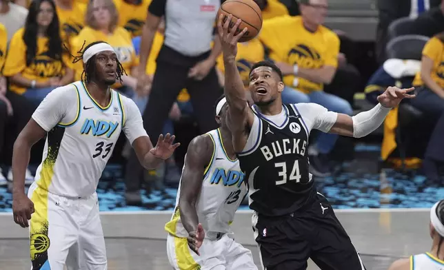 Milwaukee Bucks' Giannis Antetokounmpo (34) heads to the basket as Indiana Pacers' Myles Turner (33) defends during the first half of a first-round NBA basketball playoff game, Saturday, April 19, 2025, in Indianapolis. (AP Photo/Michael Conroy)
