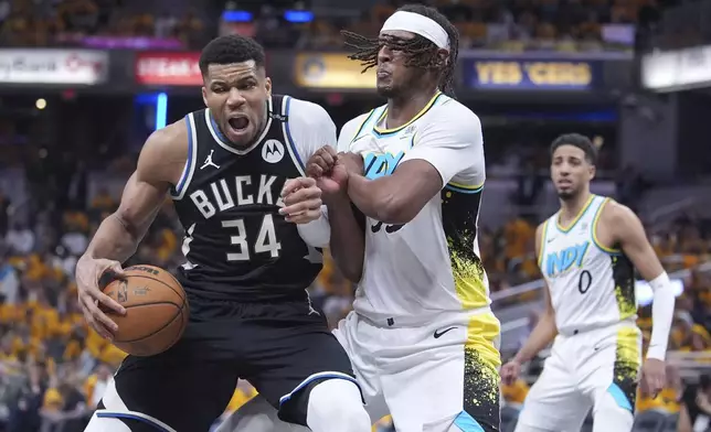 Milwaukee Bucks' Giannis Antetokounmpo (34) battles with Indiana Pacers' Myles Turner, right, during the second half of a first-round NBA basketball playoff game, Saturday, April 19, 2025, in Indianapolis. (AP Photo/Michael Conroy)