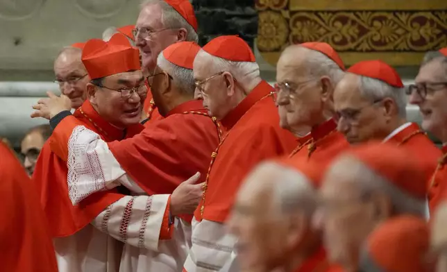FILE - Cardinal Tarcisio Isao Kikuchi, Archbishop of Tokyo, left, is congratulated by fellow cardinals after being elevated by Pope Francis during a solemn Mass in St. Peter's Basilica at the Vatican, Dec. 7, 2024. (AP Photo/Gregorio Borgia, File)