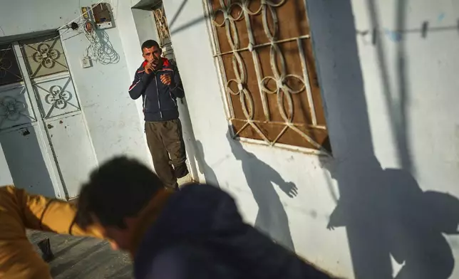 Shepherd Jalal Ma'rouf, 22, who lost a limb to a landmine while herding sheep in farmland recently recaptured from regime forces, watches his friends play at his home in Deir Sunbul village, south of Idlib, Wednesday, April 9, 2025. (AP Photo/Ghaith Alsayed)