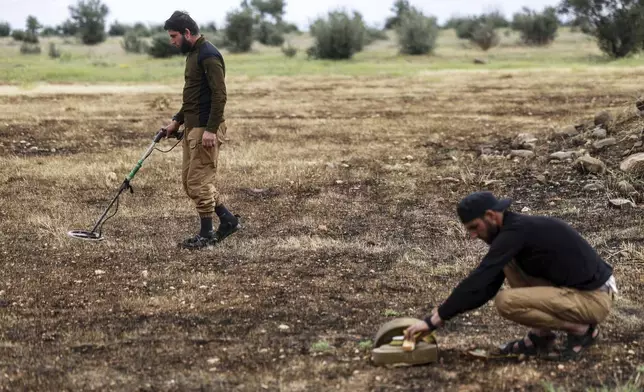 Members of the Ministry of Defence clear landmines left behind by the Syrian army during the war, in agricultural land south of Idlib, Syria, Sunday, April 13, 2025. (AP Photo/Ghaith Alsayed)