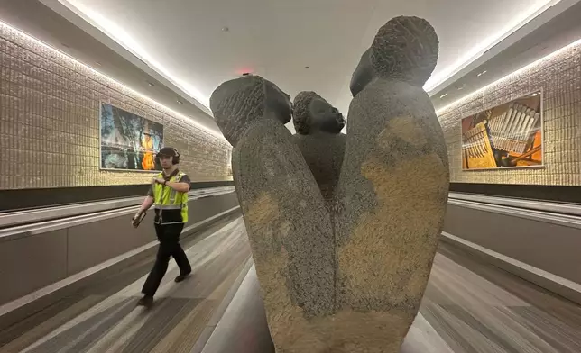 A person walks by a Zimbabwean stone art/sculpture piece at Hartsfield-Jackson Atlanta International Airport, Friday, Feb. 28, 2025, in Atlanta. (AP Photo/Ravi Nessman)