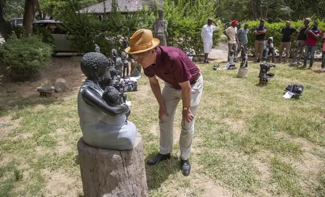 Richard Pantlin, founder of the Oxford Zimbabwe Arts Project, checks a sculpture that will be part of an upcoming exhibition at Oxford University aiming to contextualize the legacy of British imperialist Cecil John Rhodes, at the Chitungwiza Arts Centre near Harare, Zimbabwe, March 4, 2025. (AP Photo/Aaron Ufumeli)