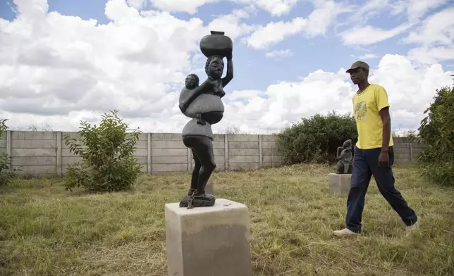Derrick Fombe walks by his winning sculpture that will be part of an upcoming exhibition at Oxford University aiming to contextualize the legacy of British imperialist Cecil John Rhodes, at the Chitungwiza Arts Centre, near Harare, Zimbabwe, on March 8, 2025. (AP Photo/Aaron Ufumeli)