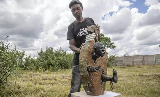 Gift Mutsauni holds his winning sculpture that will be part of an upcoming exhibition at Oxford University aiming to contextualize the legacy of British imperialist Cecil John Rhodes at the Chitungwiza Arts Centre near Harare, Zimbabwe, on March 8, 2025. (AP Photo/Aaron Ufumeli)
