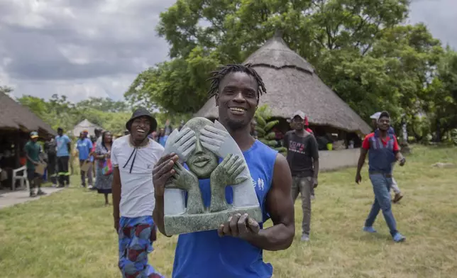 Wallace Mkanka holds his winning sculpture that will be part of an upcoming exhibition at Oxford University aiming to contextualize the legacy of British imperialist Cecil John Rhodes, at the Chitungwiza Arts Centre near Harare, Zimbabwe, on March 8, 2025. (AP Photo/Aaron Ufumeli)